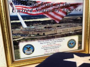 Flag and framed photo of The Pentagon with a label that reads 