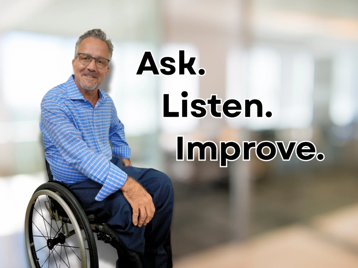 Andy in his wheelchair with the words "Ask. Listen. Improve." on top of his image
